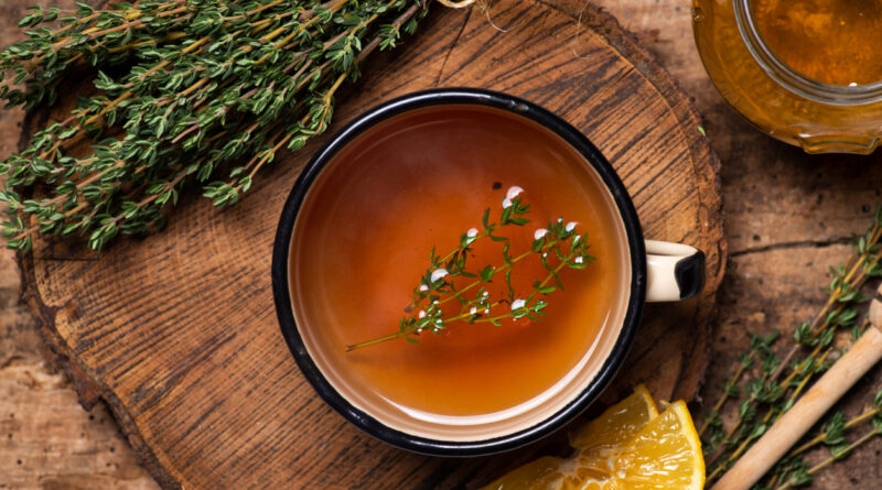 Garden thyme tea with fresh thyme leaves bunch on rustic table