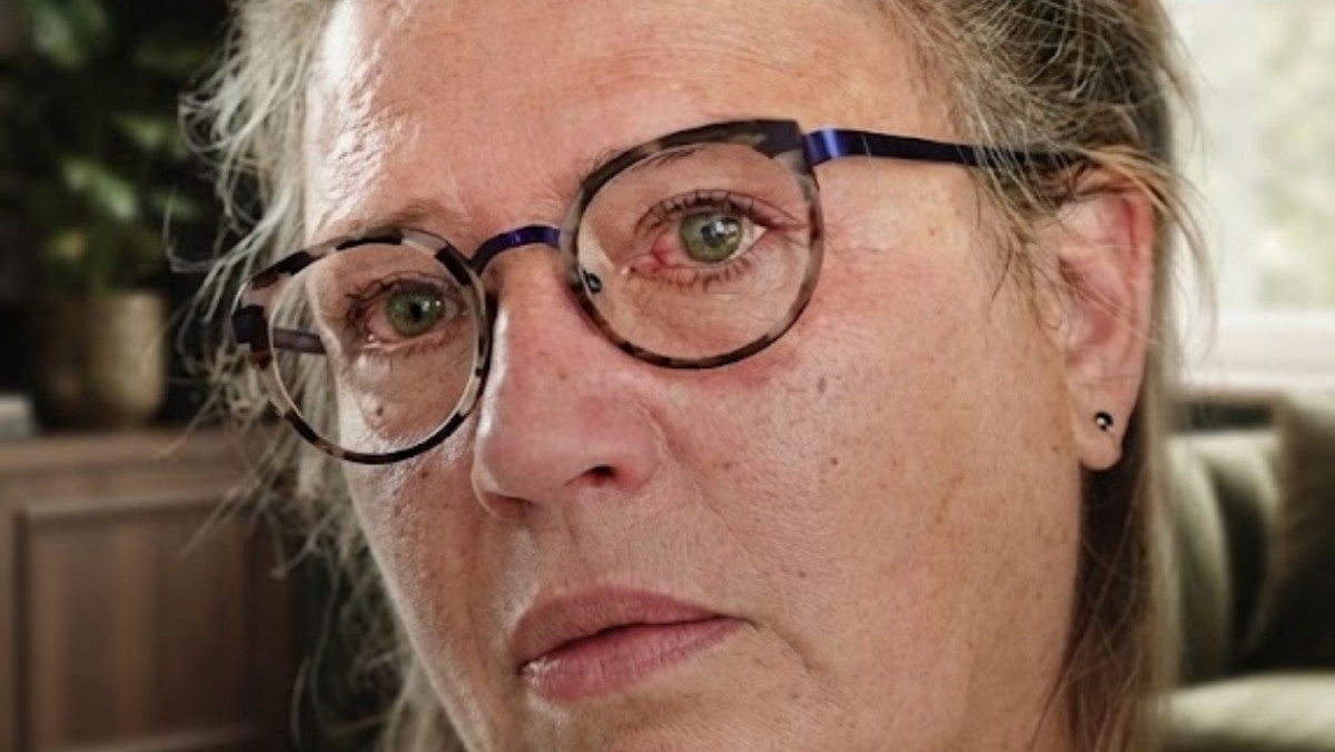 Gros plan d'une mère émue et en colère, témoignant après la censure de la loi sur la protection des enfants sur les réseaux sociaux.